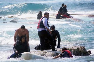 Un hombre rescata a una migrante en el este de la isla de Rodas, en mar Egeo, abril de 2015 